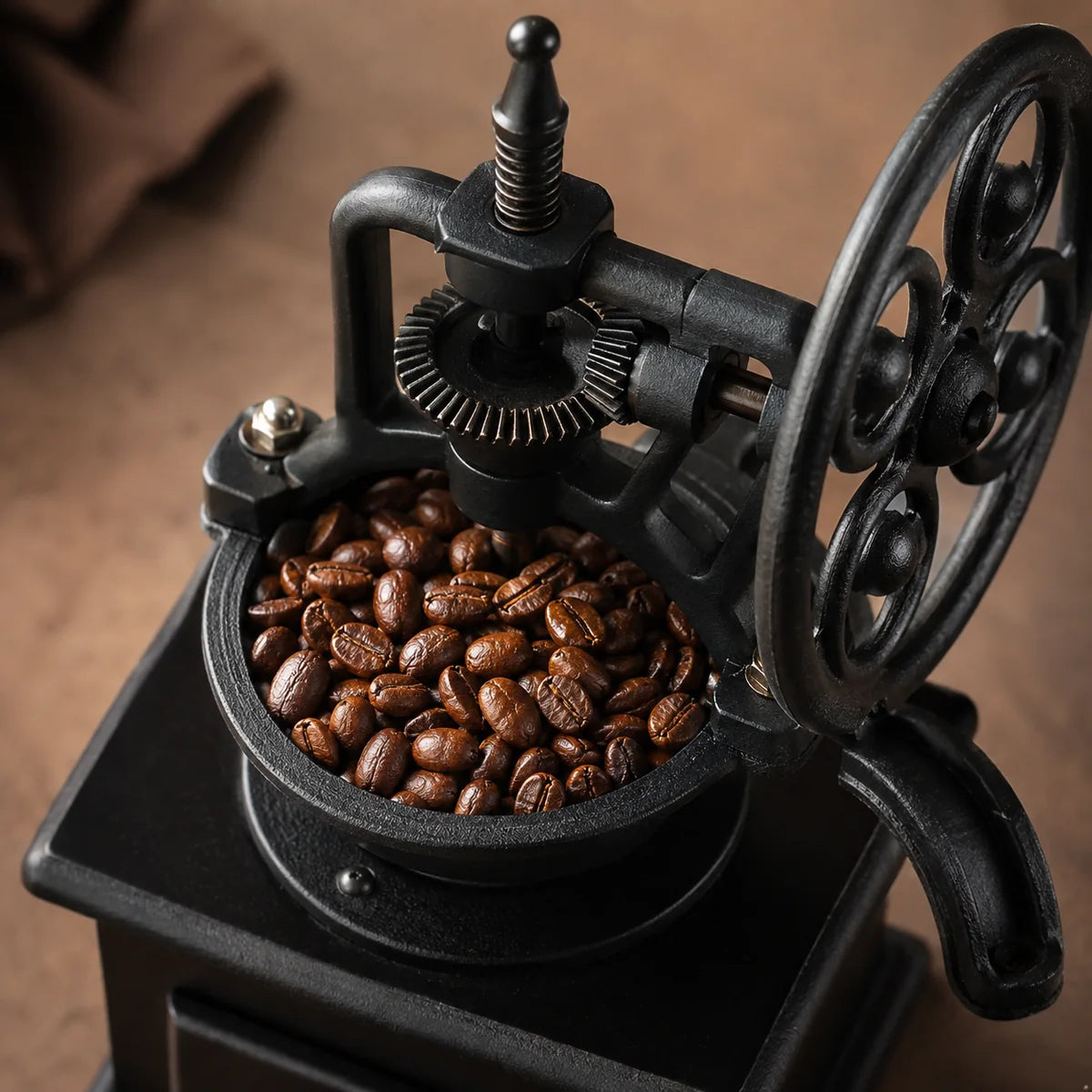 Coffee beans inside the open hopper of a manual grinder