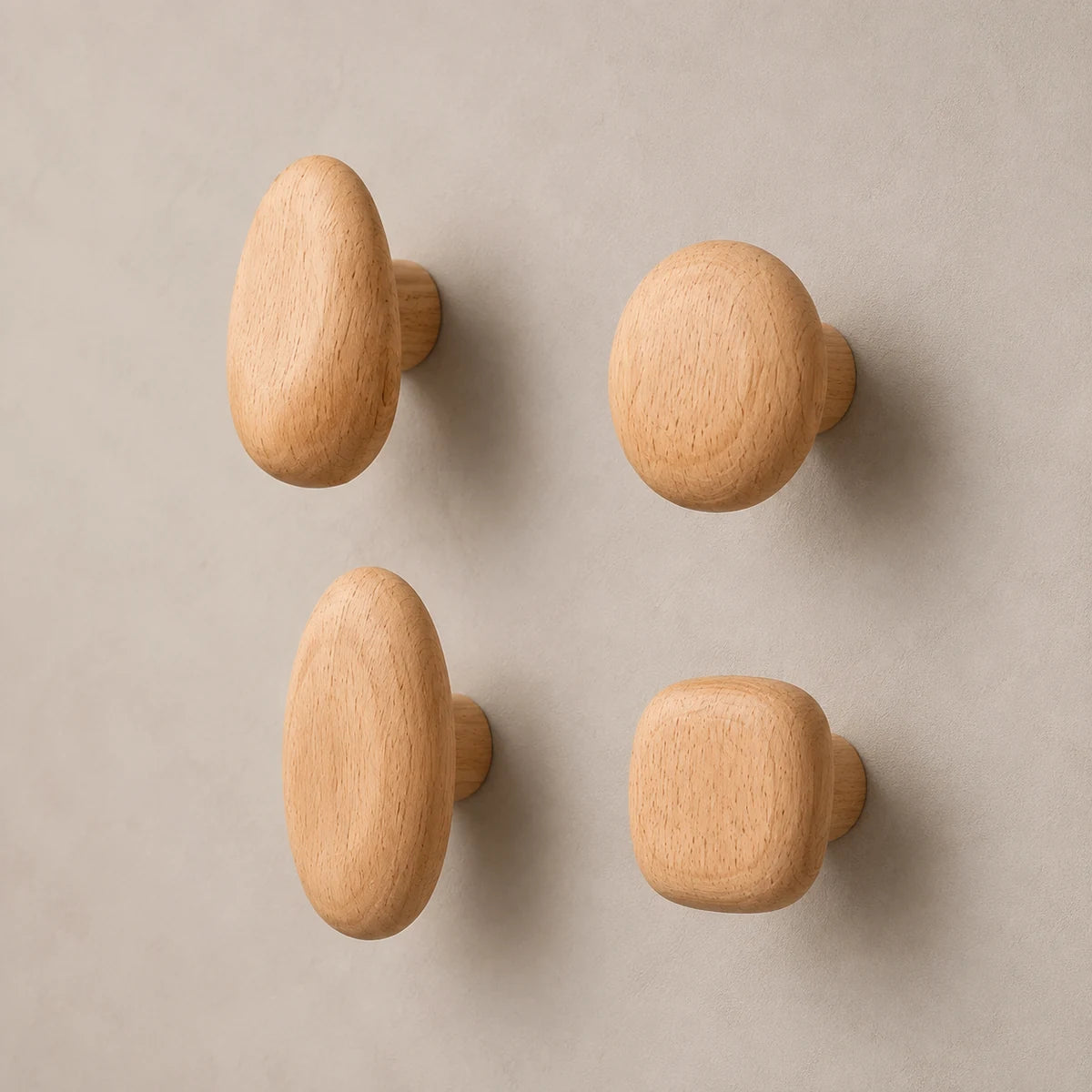 Set of four Beech Wood organic pebble wall hooks on a clean contrasting wall
