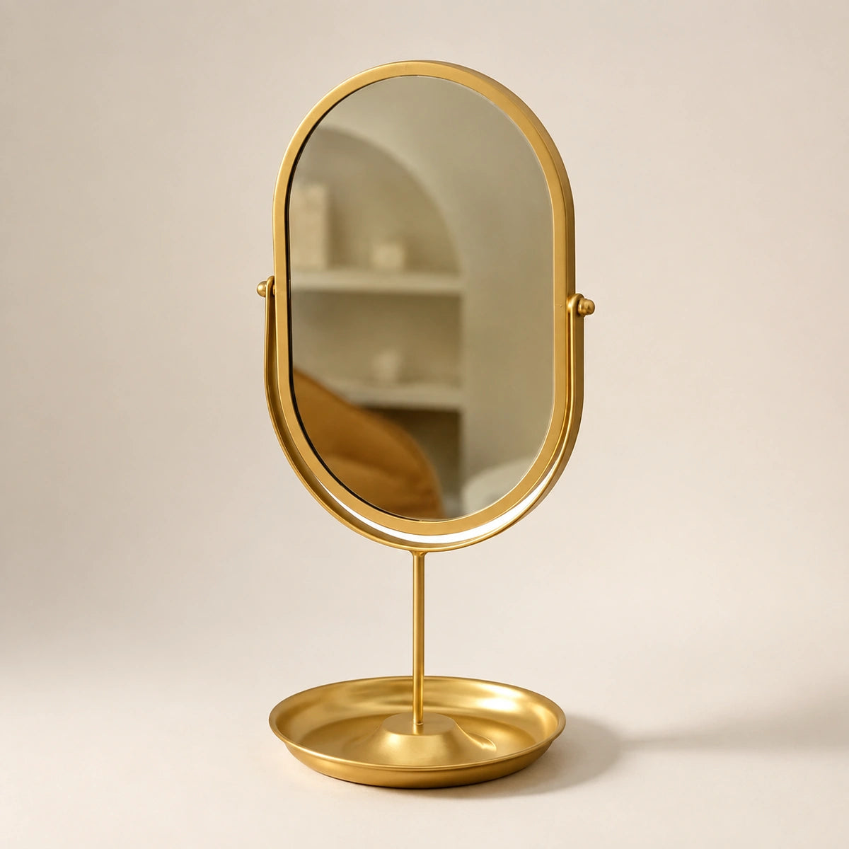 Gold oval wrought iron vanity mirror on a clean ivory background