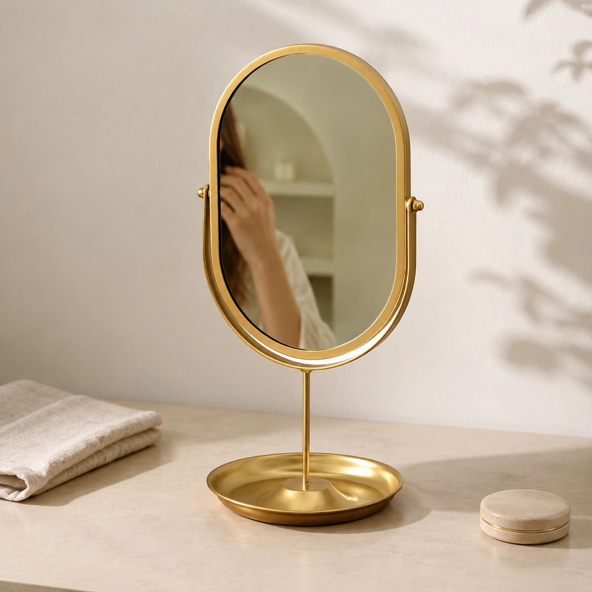 Gold oval vanity mirror in an elegant daily grooming setting