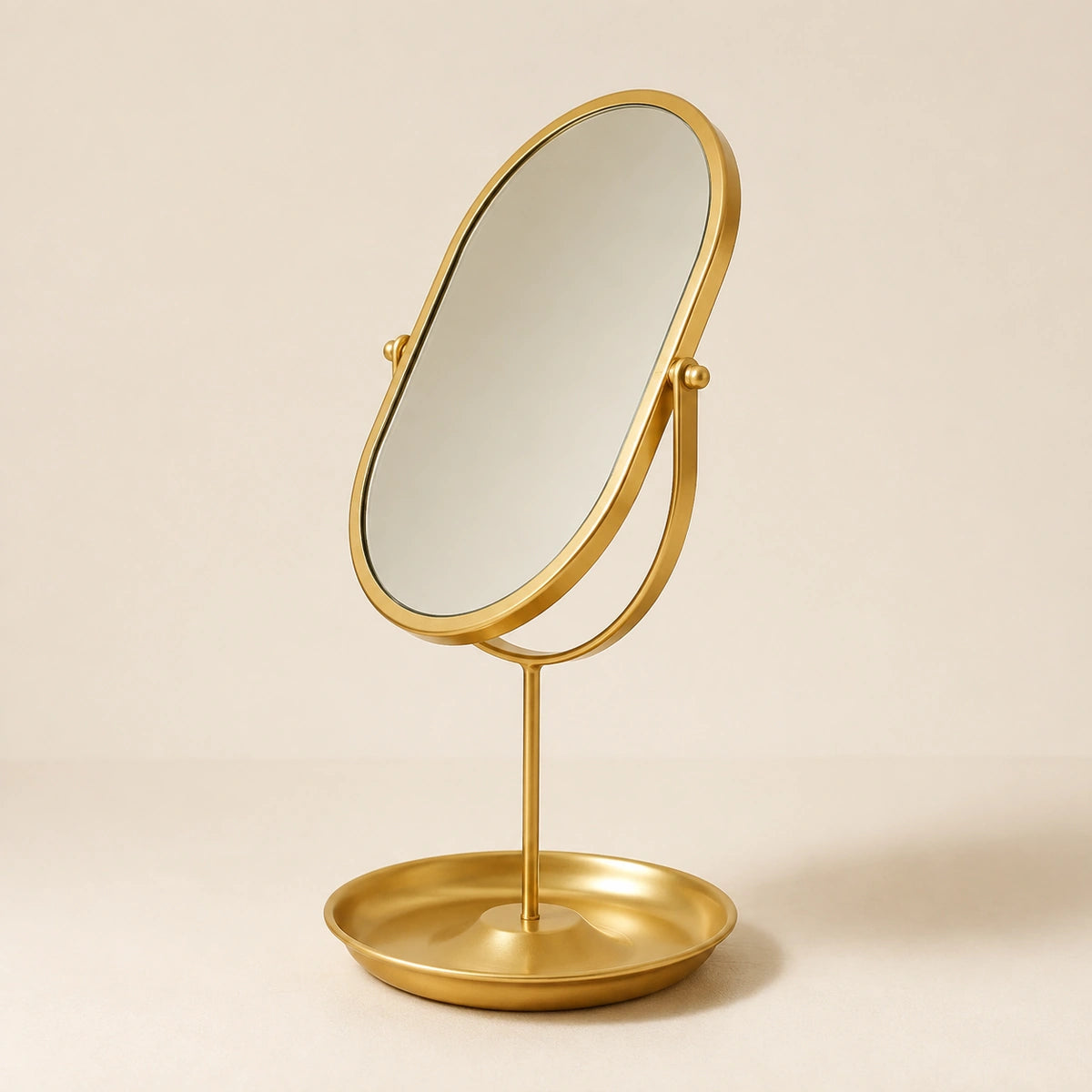 Three-quarter view of a Gold oval vanity mirror rotated on its stand