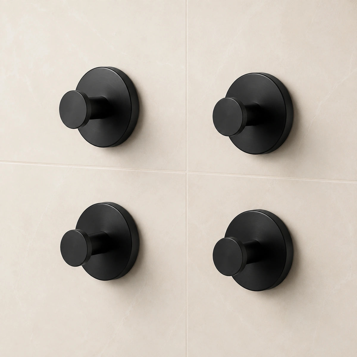 Set of four Matte Black vacuum suction wall hooks on warm ivory tile