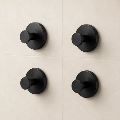 Set of four Matte Black vacuum suction wall hooks on warm ivory tile