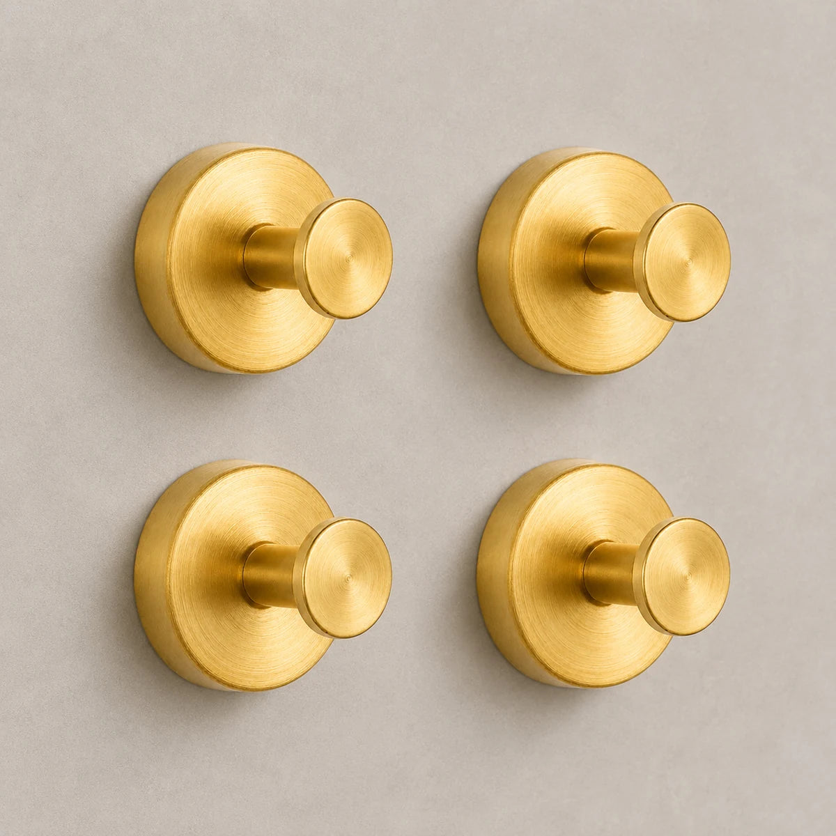 Set of four Gold vacuum suction wall hooks on warm-gray tile