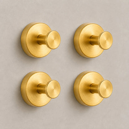 Set of four Gold vacuum suction wall hooks on warm-gray tile