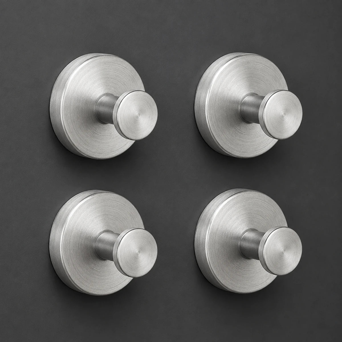 Set of four Silver vacuum suction wall hooks on charcoal-gray tile